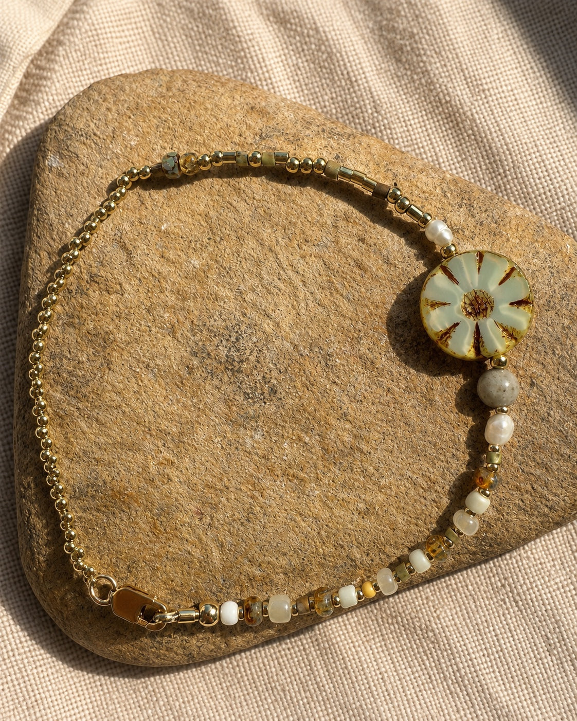 Full view of the SUNSABI BLOOM bracelet with Czech glass flower, natural stone, pearl and gold-filled chain.