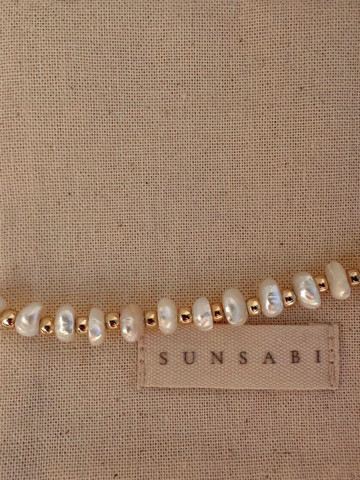 Close-up of luminous freshwater pearls and gold-filled details on a SUNSABI bracelet