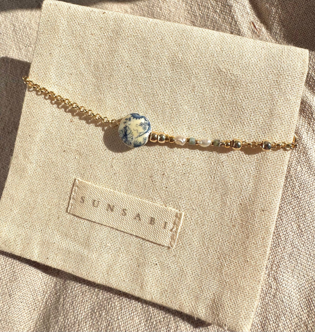 Portobello Sky handmade bracelet in natural light with vintage Tensha bead, freshwater pearls, Miyuki beads and 14k gold-filled chain