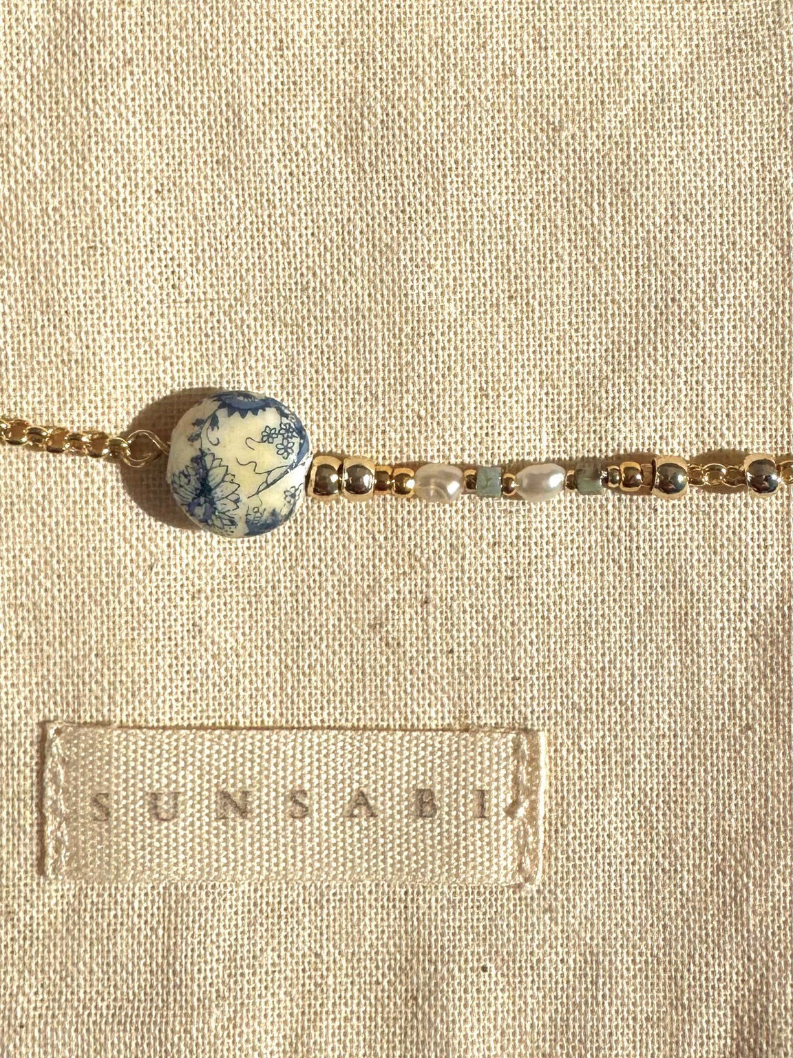 Detail of Portobello Sky bracelet with vintage floral Tensha bead, freshwater pearls, Miyuki beads and 14k gold-filled accents