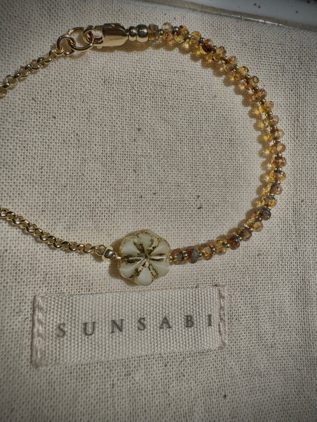 Full view of the SUN BEAM honey glass bead bracelet with 14k gold-filled details and floral focal