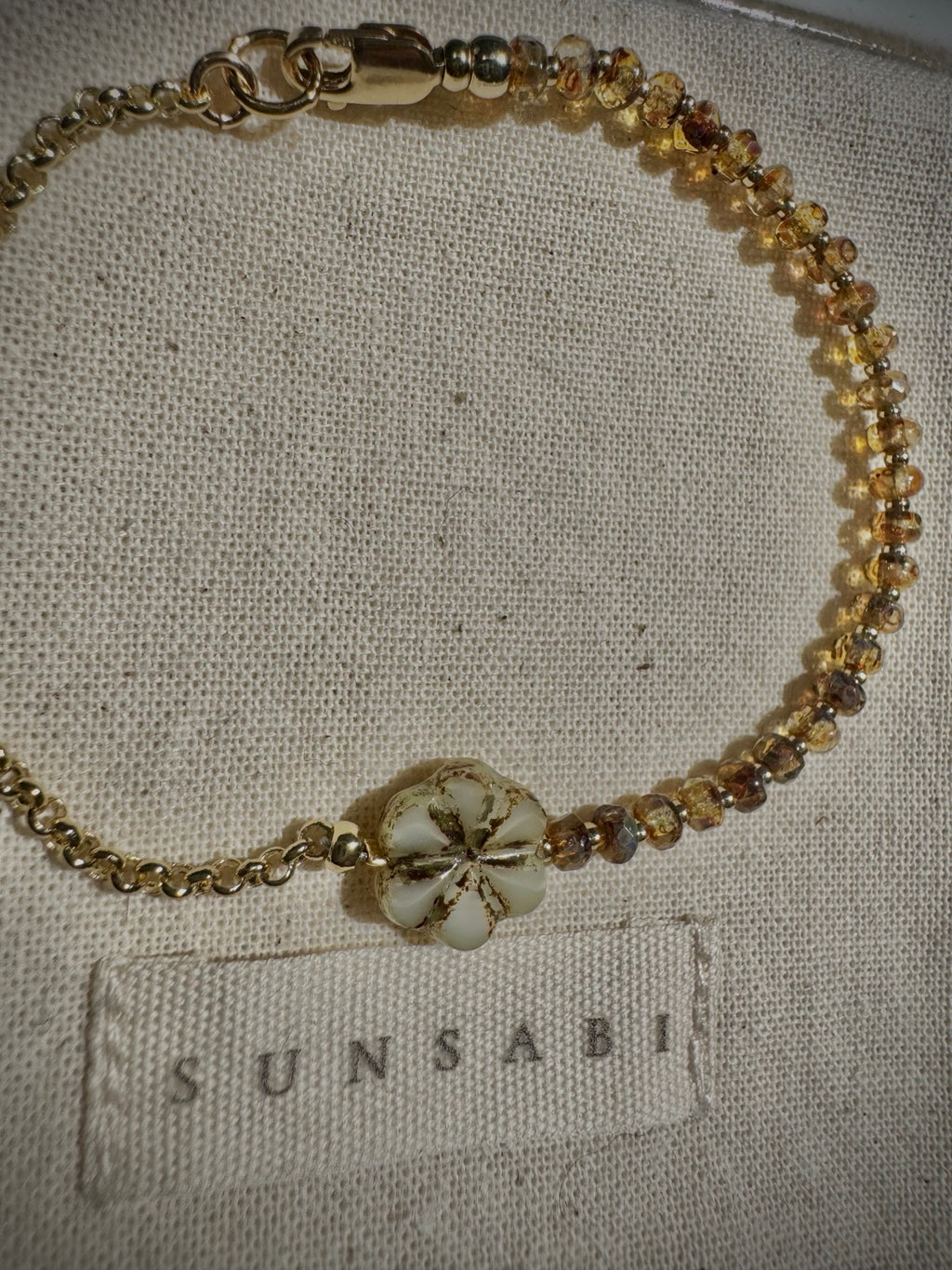 Close-up of the Picasso-finished ivory floral glass bead and honey glass beads on the SUN BEAM bracelet