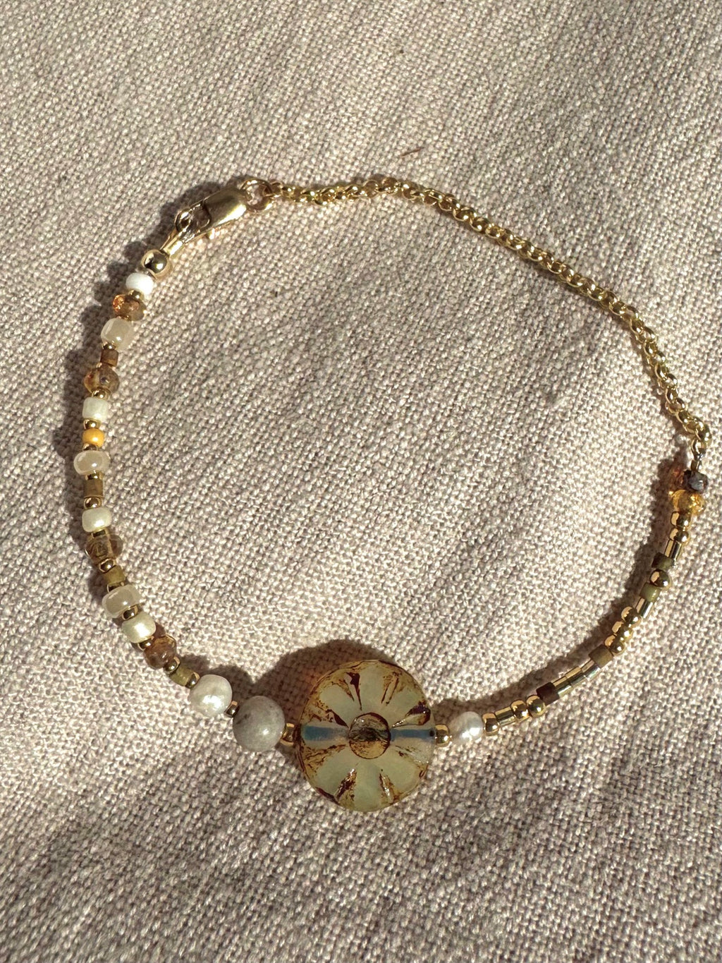 SUN BLOOM No. 01 handmade pearl and glass bead bracelet arranged in a circle on natural linen