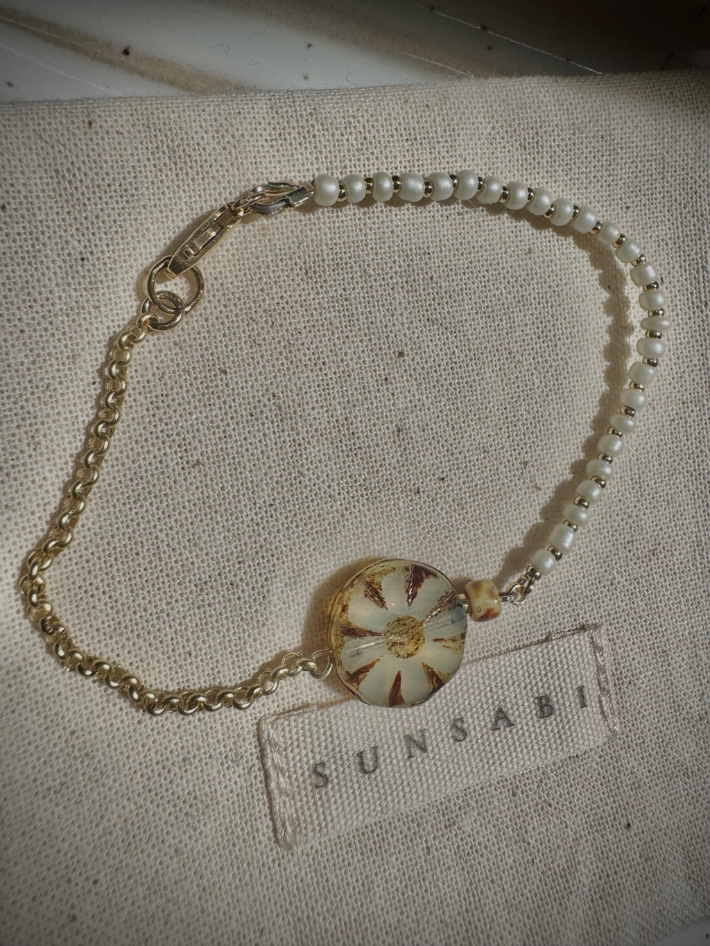 Full view of SUN BLOOM No. 03 with ivory glass seed beads, 14k gold-filled details, rolo chain and Picasso Czech bloom