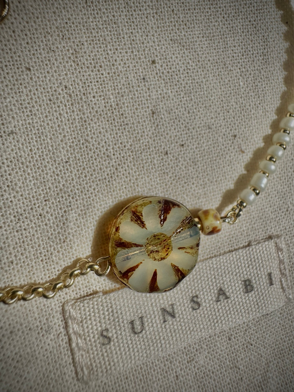 Close-up of the ivory Picasso Czech glass bloom, gold-filled rolo chain and glass bead details on SUN BLOOM No. 03